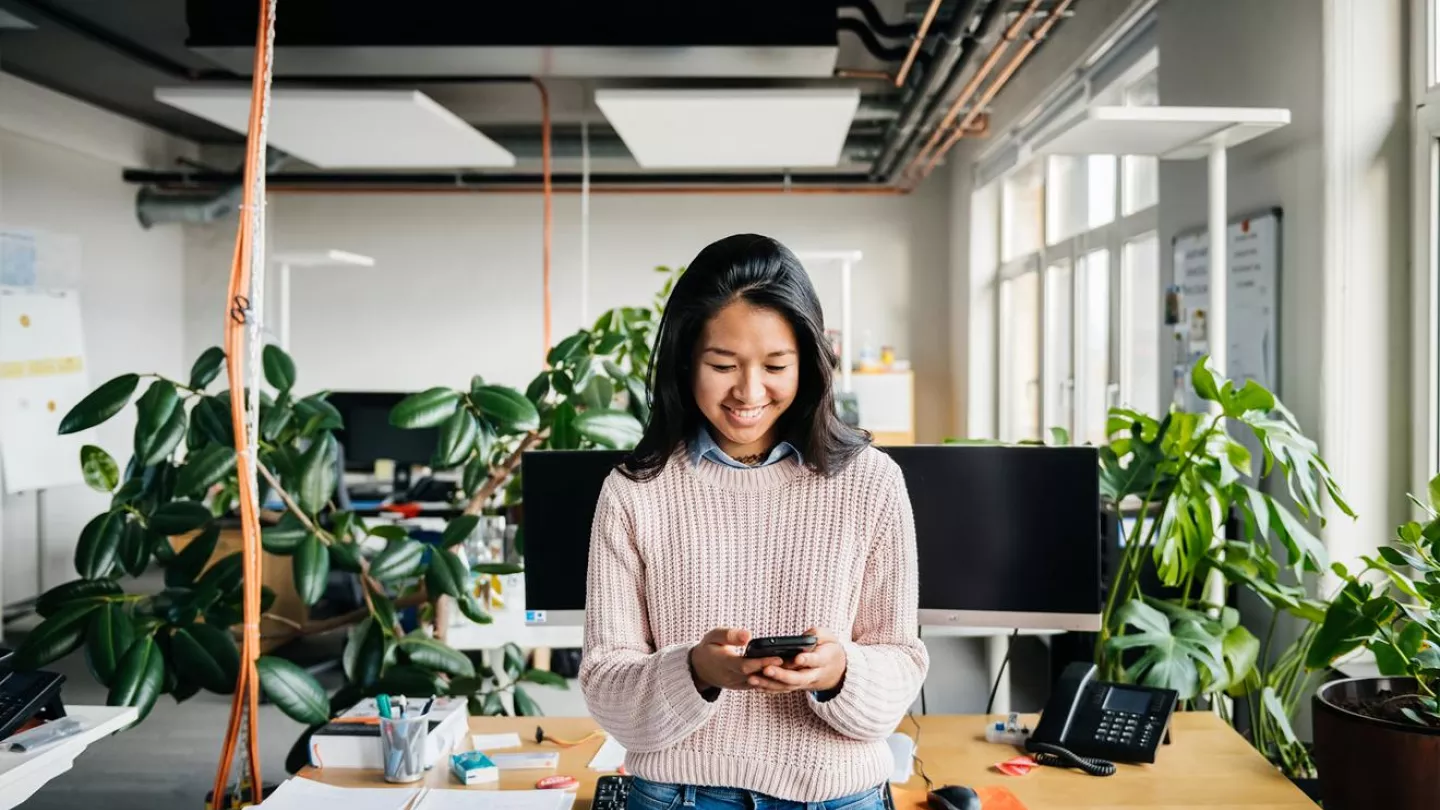 Woman looking at her phone in an office