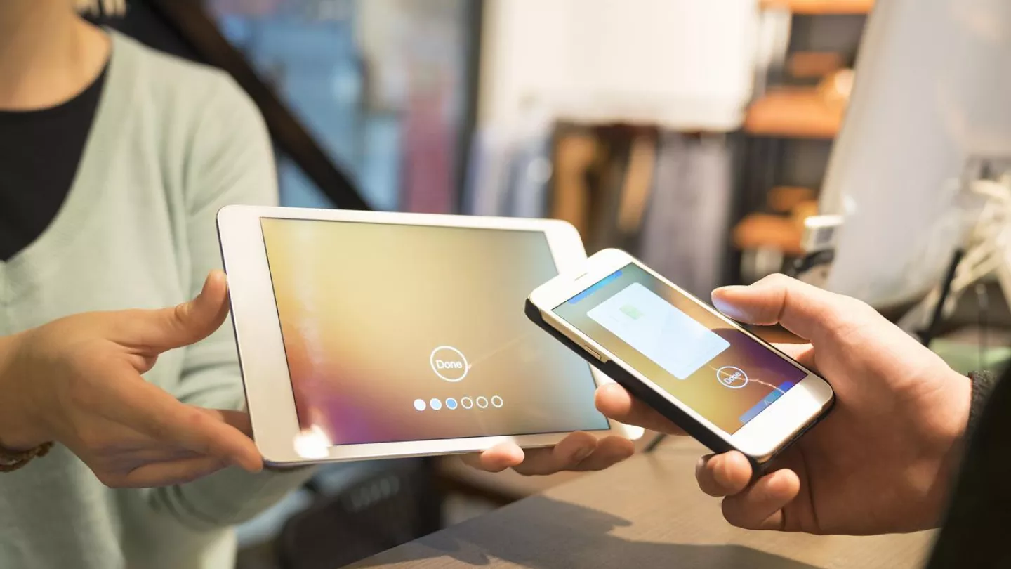 A person pays with his smartphone at a store