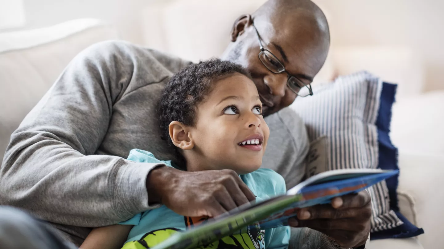 A father and son enjoying a book they received from a program they joined via short code enrollment